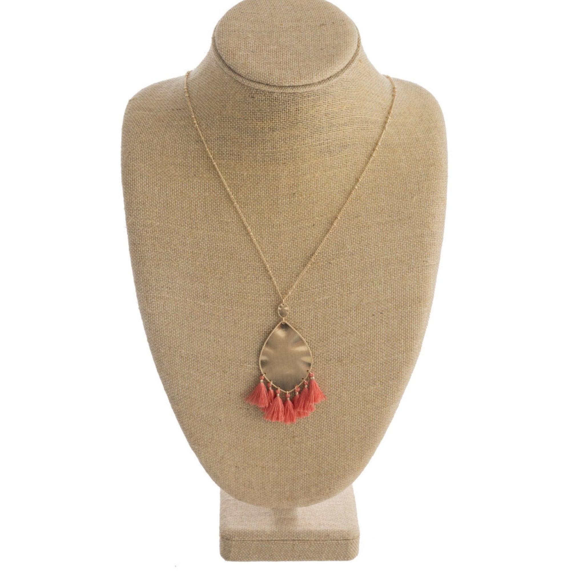 Long metal necklace featuring a metal plated teardrop pendant with tassel details and gold accents