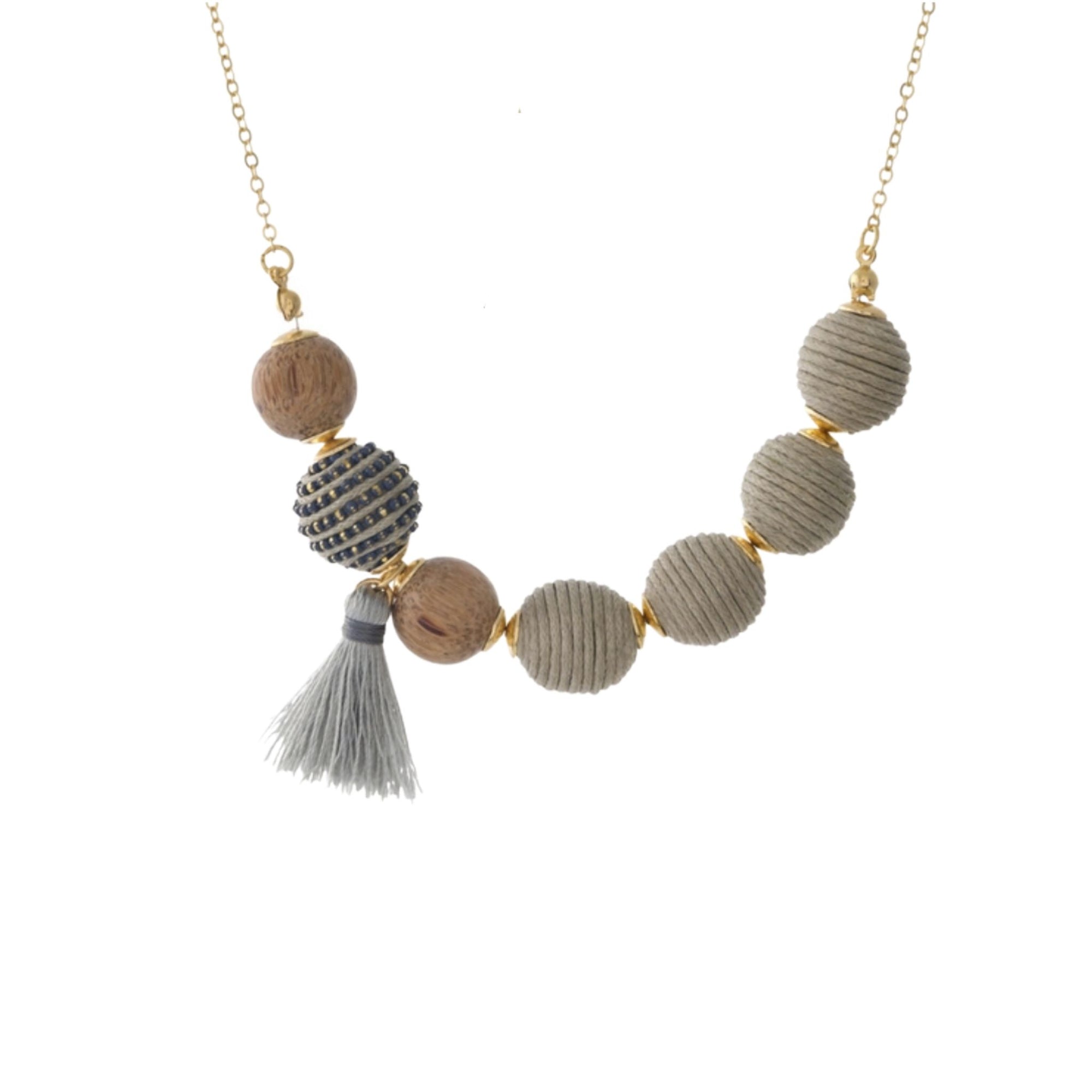 Gold tone necklace set with gray thread wrapped beads and wooden bead and tassel accents.