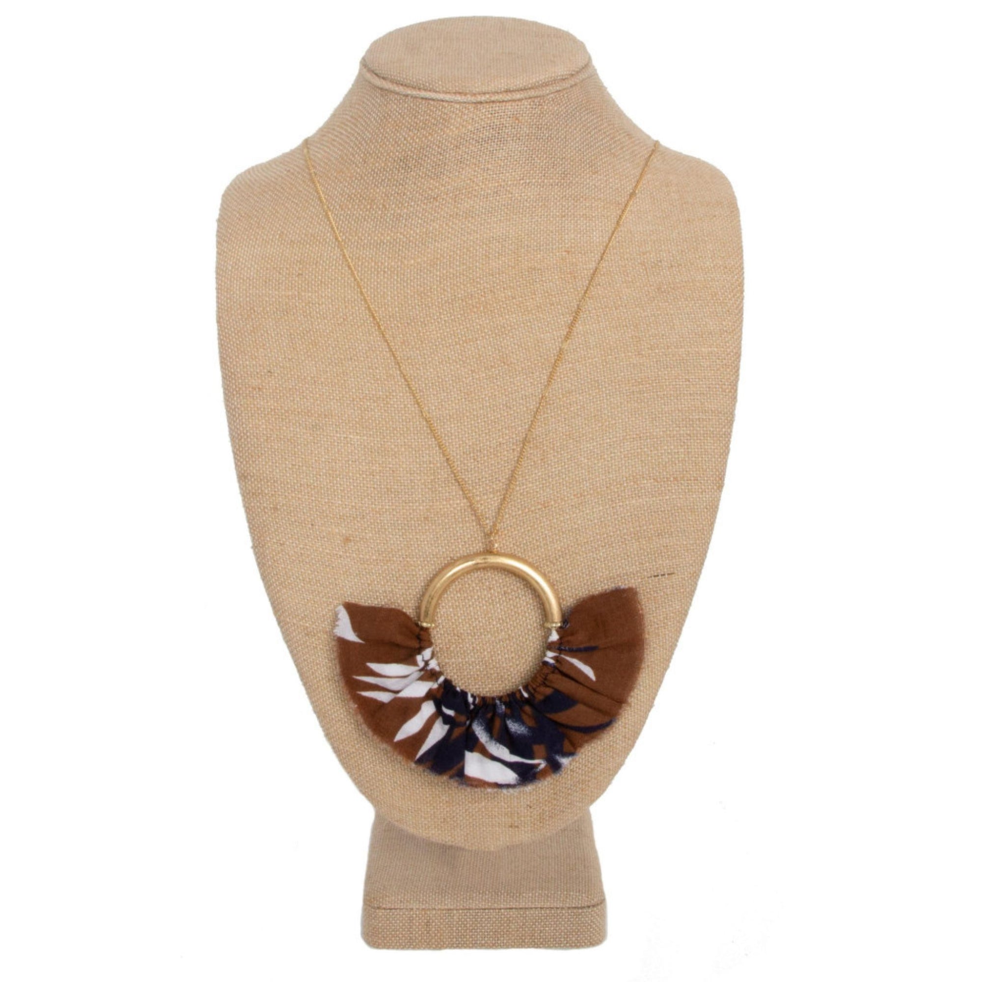 Long gold tone necklace with circle pendant with fanned fabric detail