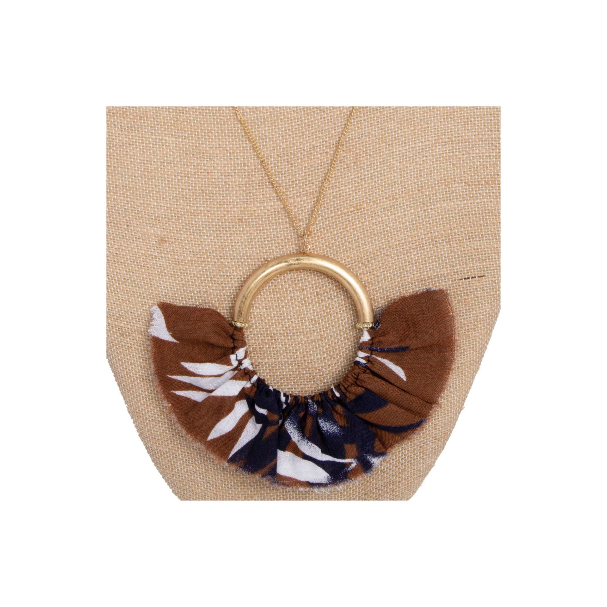 Long gold tone necklace with circle pendant with fanned fabric detail