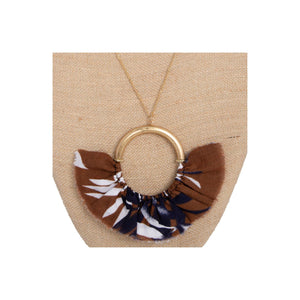 Long gold tone necklace with circle pendant with fanned fabric detail