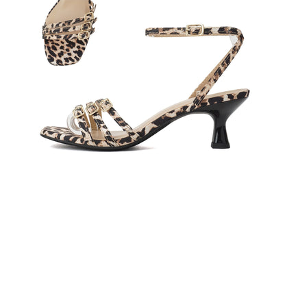 An ankle strap kitten heel sandal with a leopard print design on the straps and a textured rubber sole.