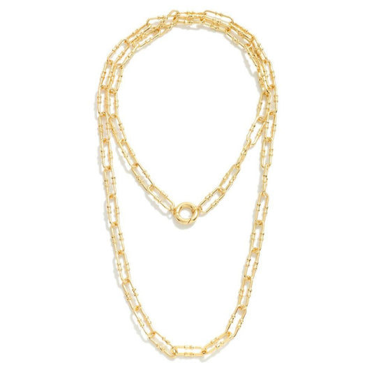 A gold chain link necklace with a hinged clip clasp, displayed in a layered style.